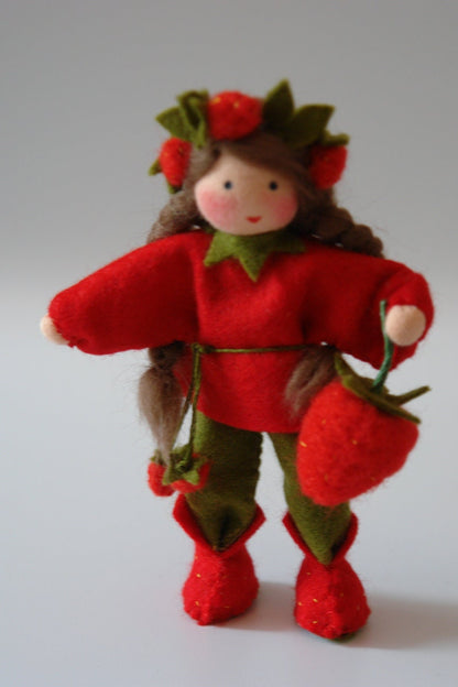Handgefertigtes Erdbeer-Blumenkind aus Wollfilz mit rotem Kleid, Erdbeeren im Haar und großer Erdbeerfrucht für den Sommer-Jahreszeitentisch.