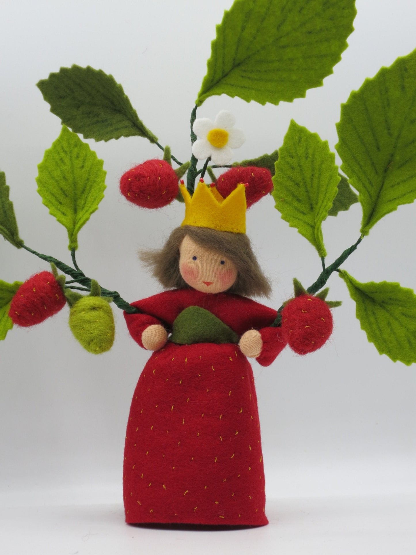 Erdbeerprinzessin aus Wollfilz mit gelber Krone, Erdbeerblüte und roten Erdbeeren als Waldorf-Sommerdekoration.