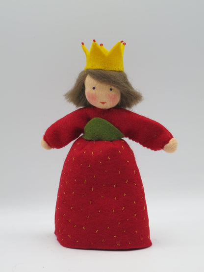 Frontalansicht der Erdbeerprinzessin aus Wollfilz mit gelber Krone, rotem Kleid und grünem Blatt am Sommer-Jahreszeitentisch.