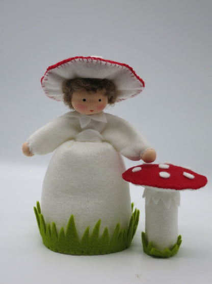 Handgefertigtes Fliegenpilz-Blumenkind aus Wollfilz mit weißem Kleid, Pilzhut und rotem Fliegenpilz für den Herbst-Jahreszeitentisch.