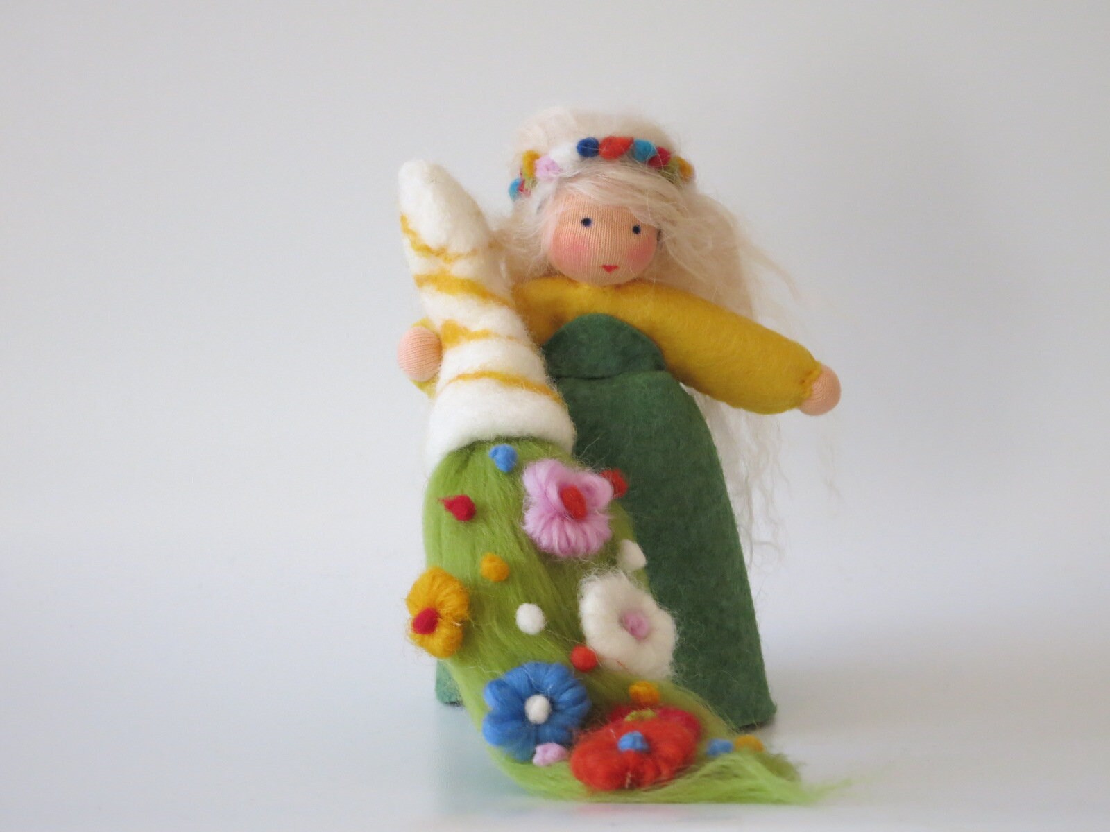 Handgefertigte Frühlingsfigur mit grün-gelbem Filzgewand, Blumenwiese und hellem Frühlingszweig für den Jahreszeitentisch