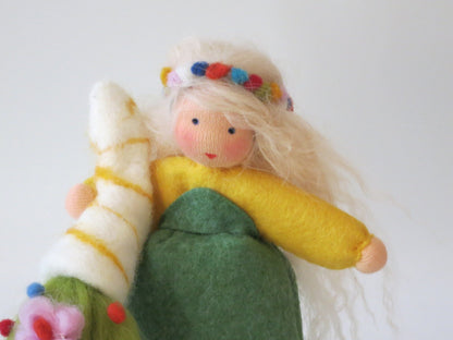 Detail der handgefertigten Frühlingsfigur mit blondem Wollhaar, buntem Blumenkranz und hellem Filzzweig