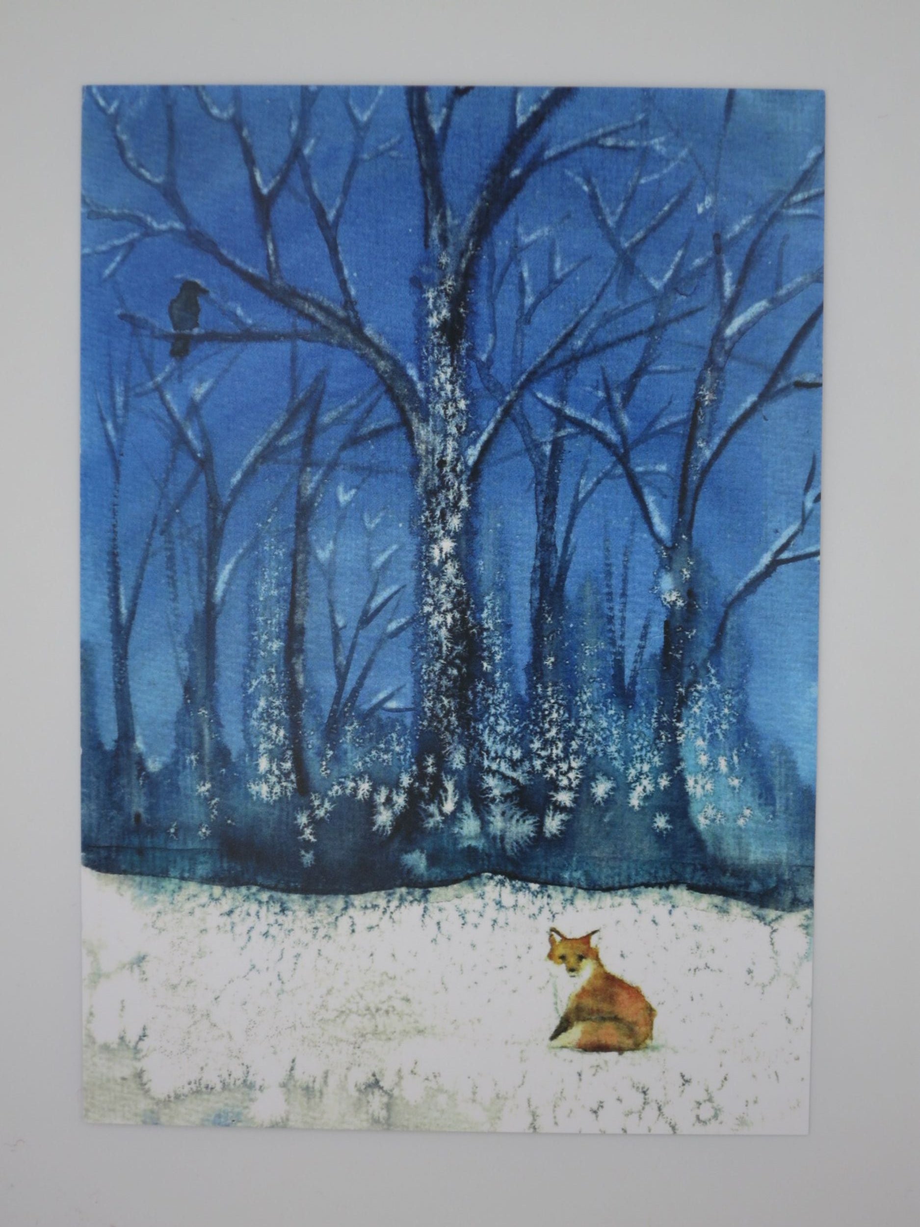 Postkarte Fuchs und Rabe von Anna Hunold, Fuchs im Schnee blickt zu Rabe im Winterwald