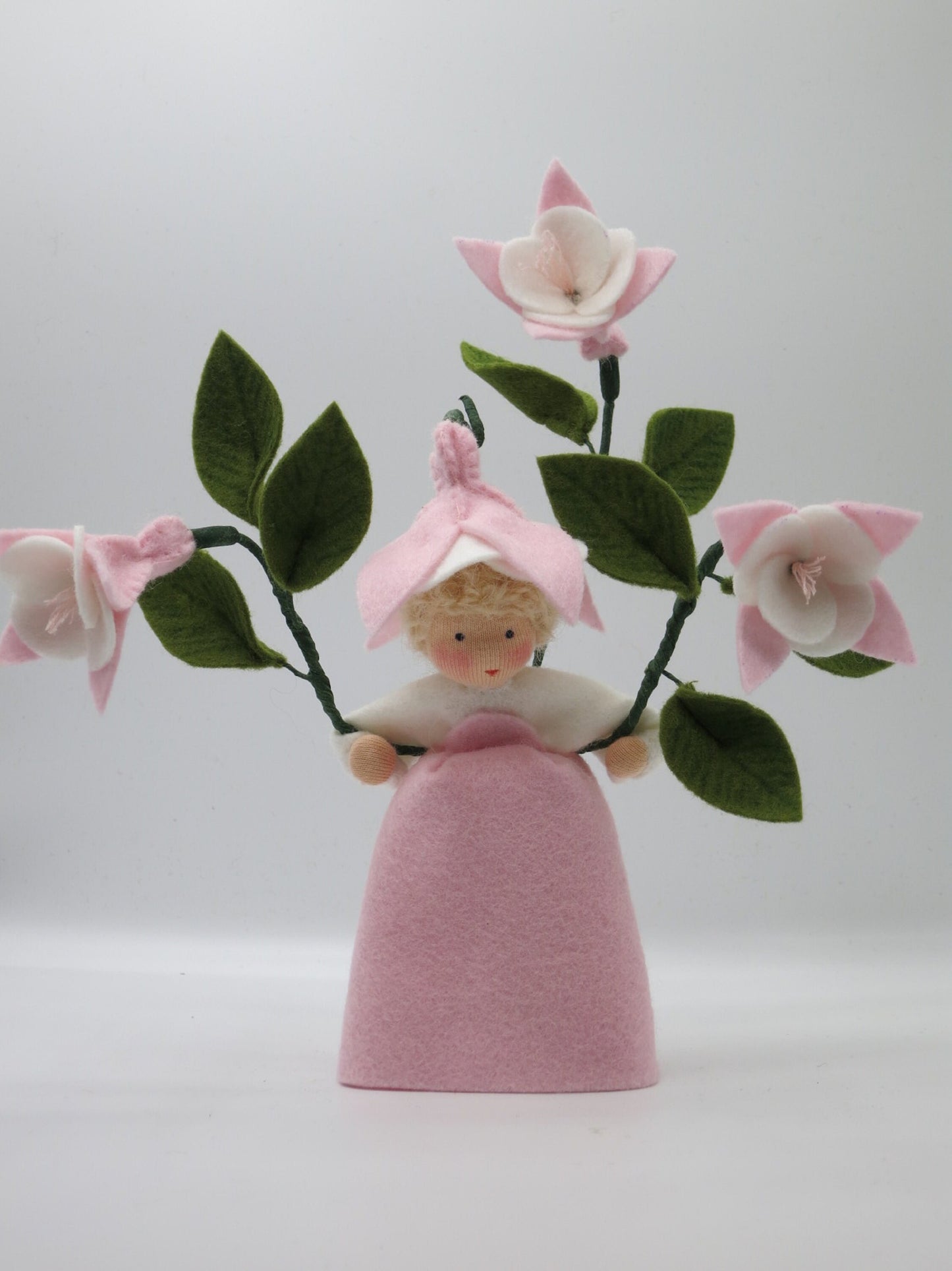 Rosafarbenes handgefertigtes Blumenkind mit Fuchsienblüten und grünen Filzblättern