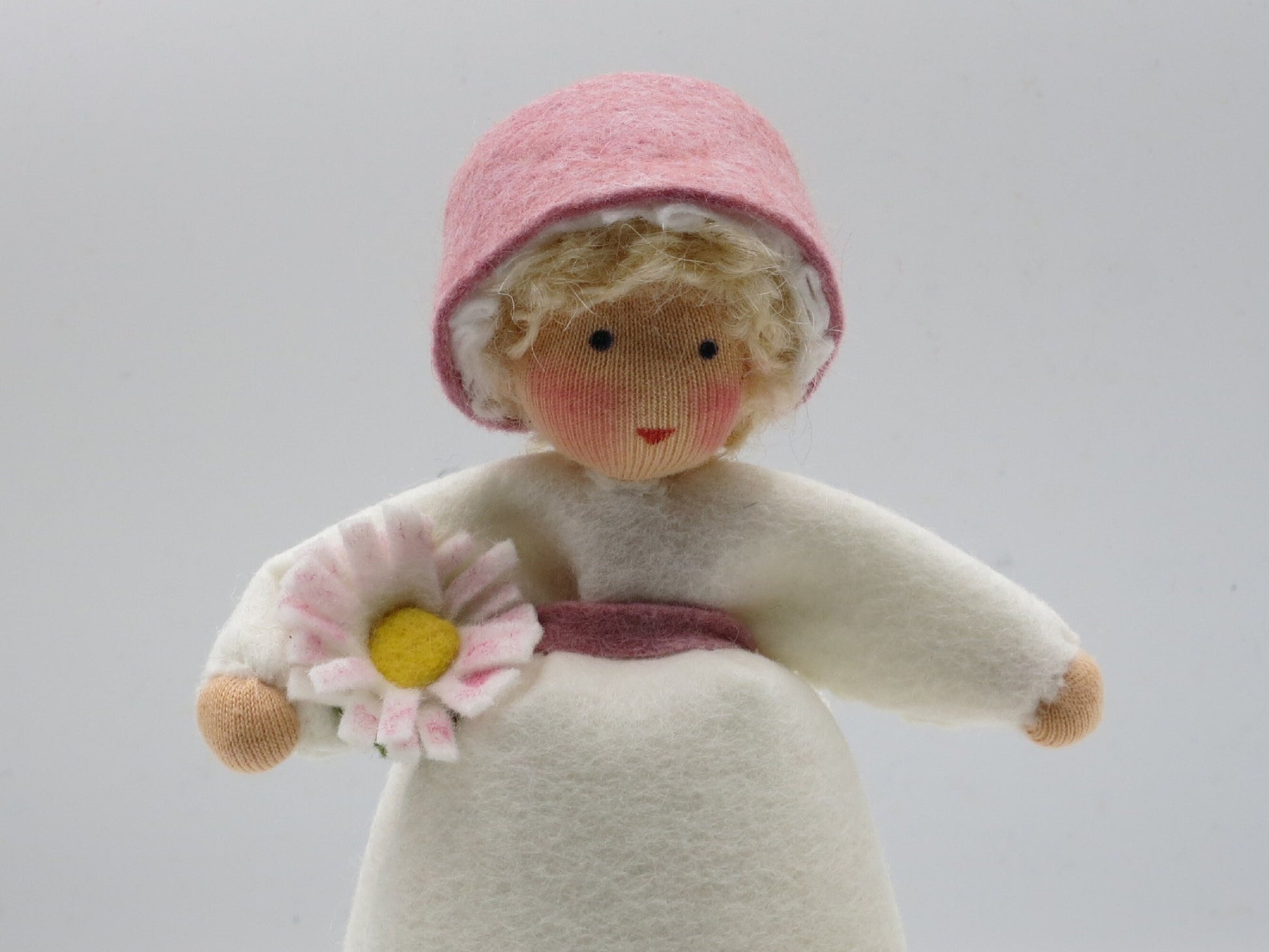Rückansicht des Gänseblümchen-Blumenkindes mit rosa Filzhaube