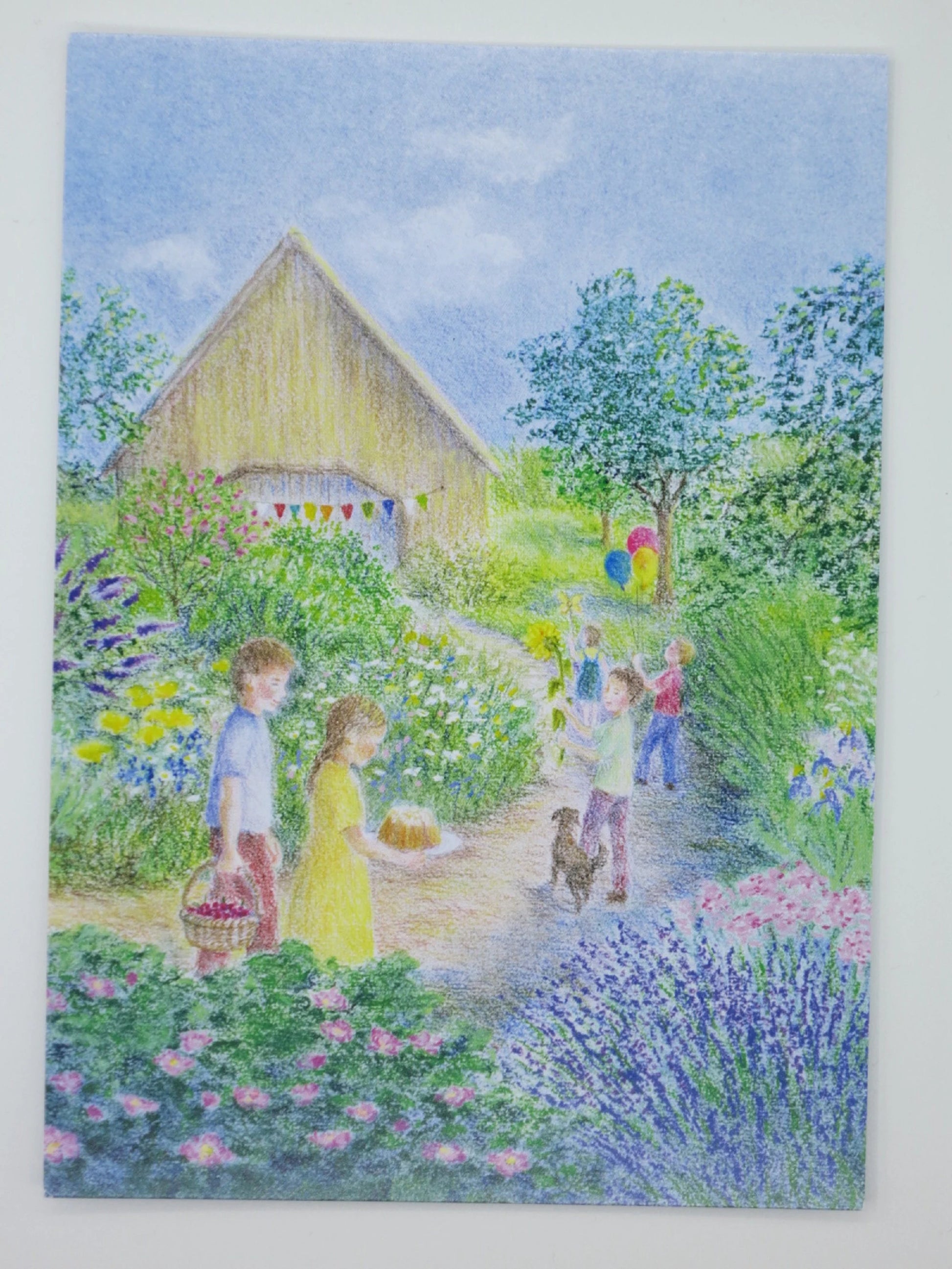 Geburtstagsfest-Postkarte mit Kindern im Blumengarten, Gugelhupf-Kuchen, Wimpelgirlande am Bauernhaus und kleinem Hund – GK26