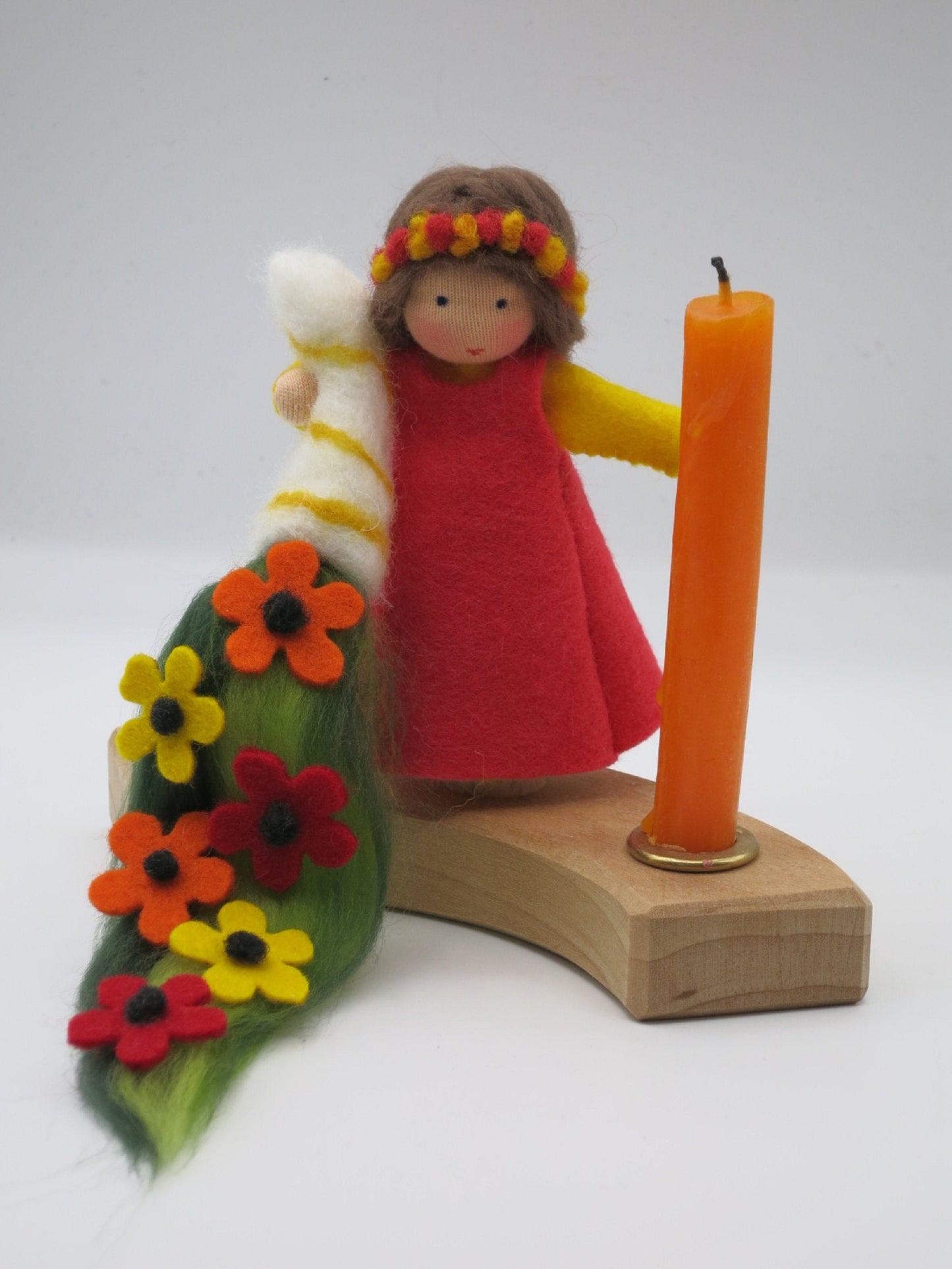 Handgefertigtes Geburtstagskind aus Wollfilz am Holz-Kerzenring mit orangefarbener Kerze, Blumenmantel und Geschenkkerze.