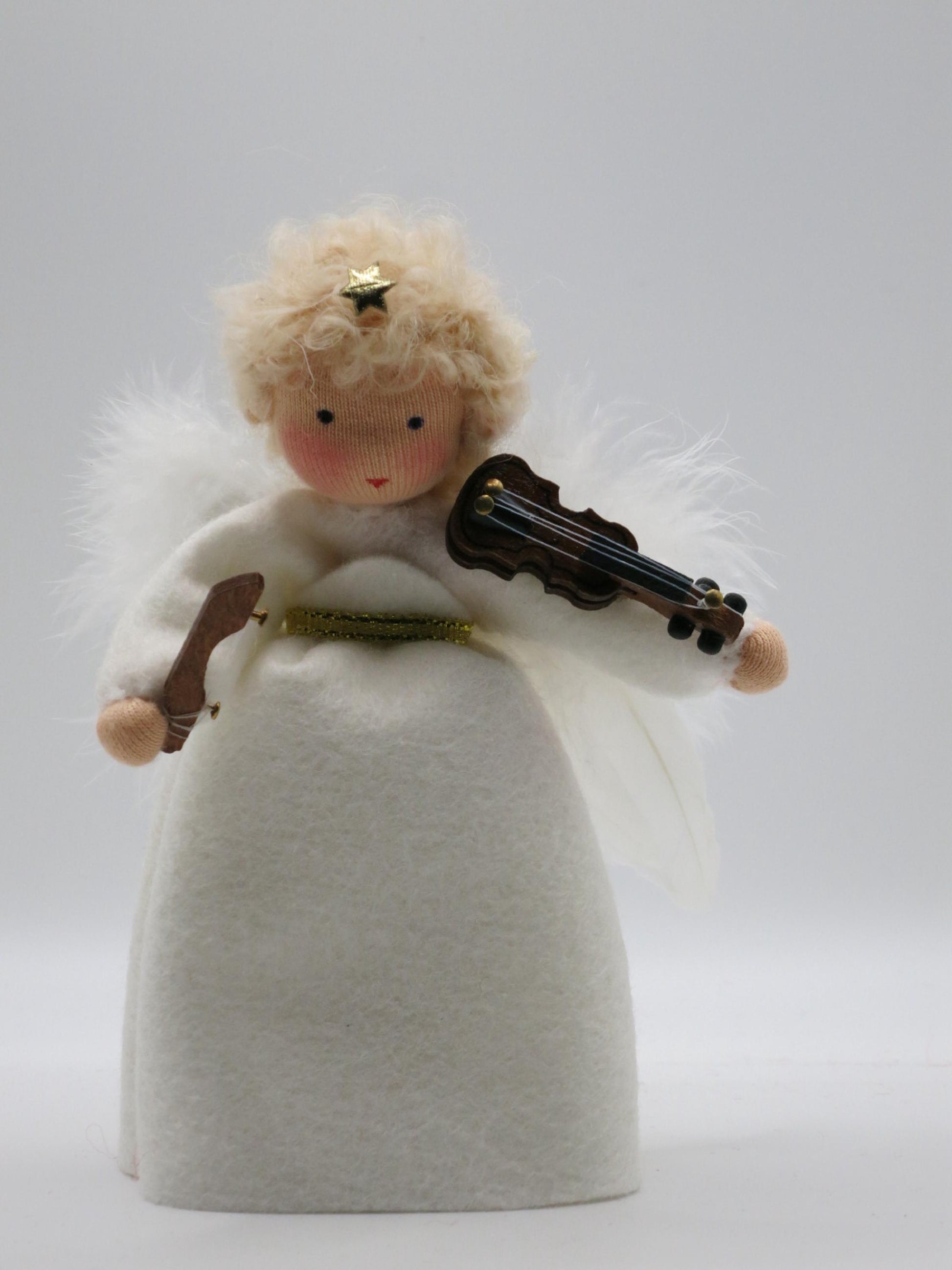 Handgefertigter Geigen-Engel aus Wollfilz mit weißem Gewand, Flügeln, goldener Schleife und kleiner Geige für den Weihnachts-Jahreszeitentisch.