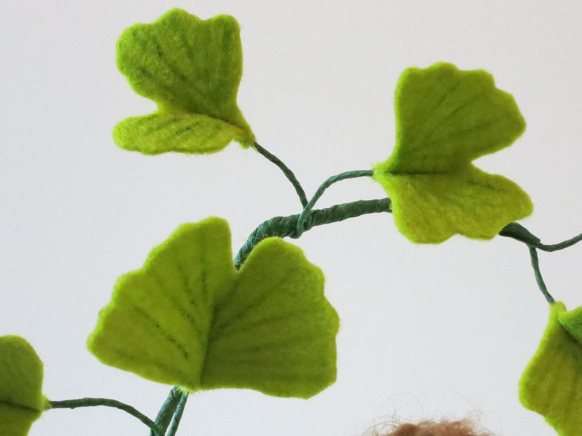 Detailansicht der fächerförmigen Ginkgoblätter aus Wollfilz am handgefertigten Blumenkind.