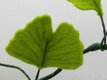 Detailansicht eines fächerförmigen Ginkgoblatts aus Wollfilz am handgefertigten Ginkgo-Mädchen.