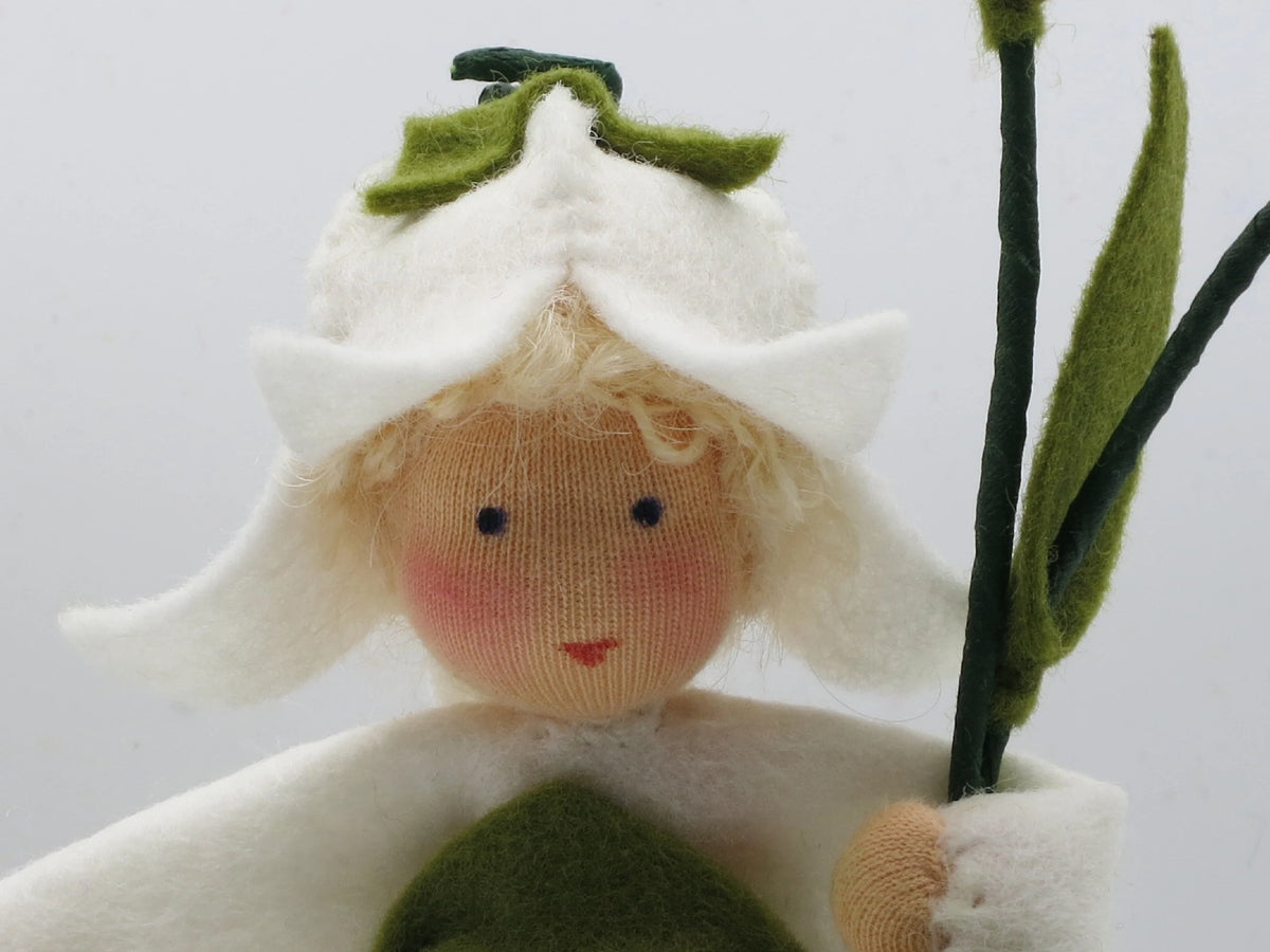 Porträt des Glockenblume-Blumenkinds mit weißer Blütenhaube und blondem Lockenhaar