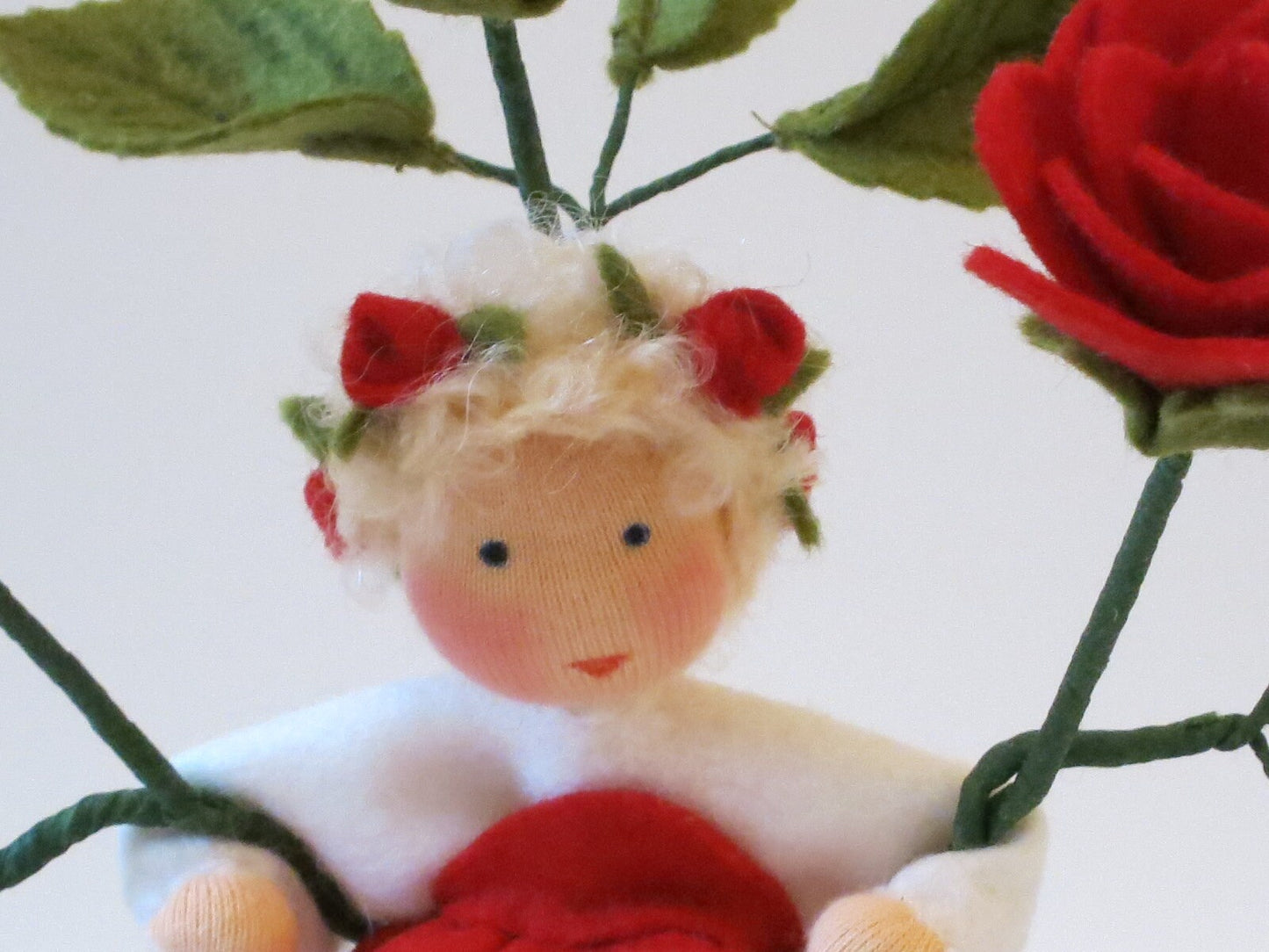 Seitenansicht des Große-Rose-Blumenkindes mit roten Rosenblüten