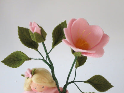 Nahaufnahme von Heckenrosen-Blüte und Knospe aus Wollfilz mit gezähnten grünen Blättern.