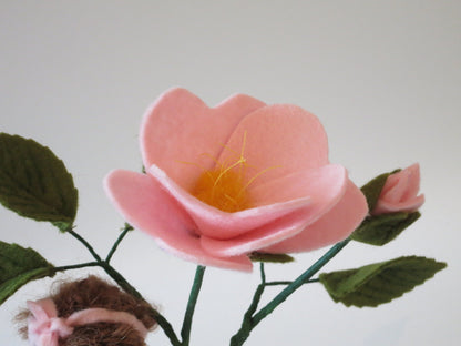 Detailansicht der rosa Heckenröschen-Blüte aus Wollfilz mit goldenen Staubgefäßen und Knospe.
