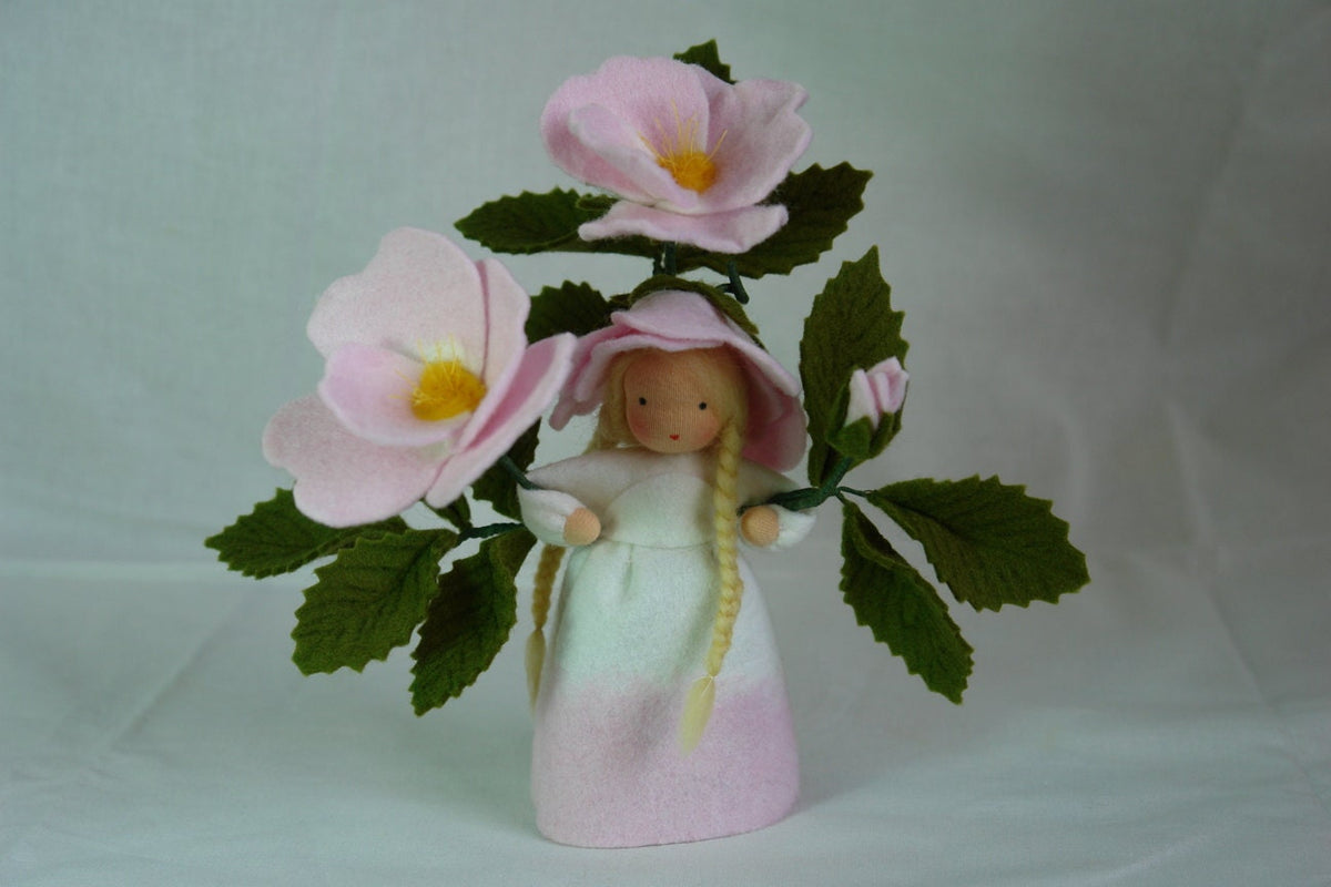 Heckenrose-Blumenkind aus Wollfilz für den Waldorf Jahreszeitentisch mit zwei geöffneten Blüten, einer Knospe und rosa Blütenhütchen.