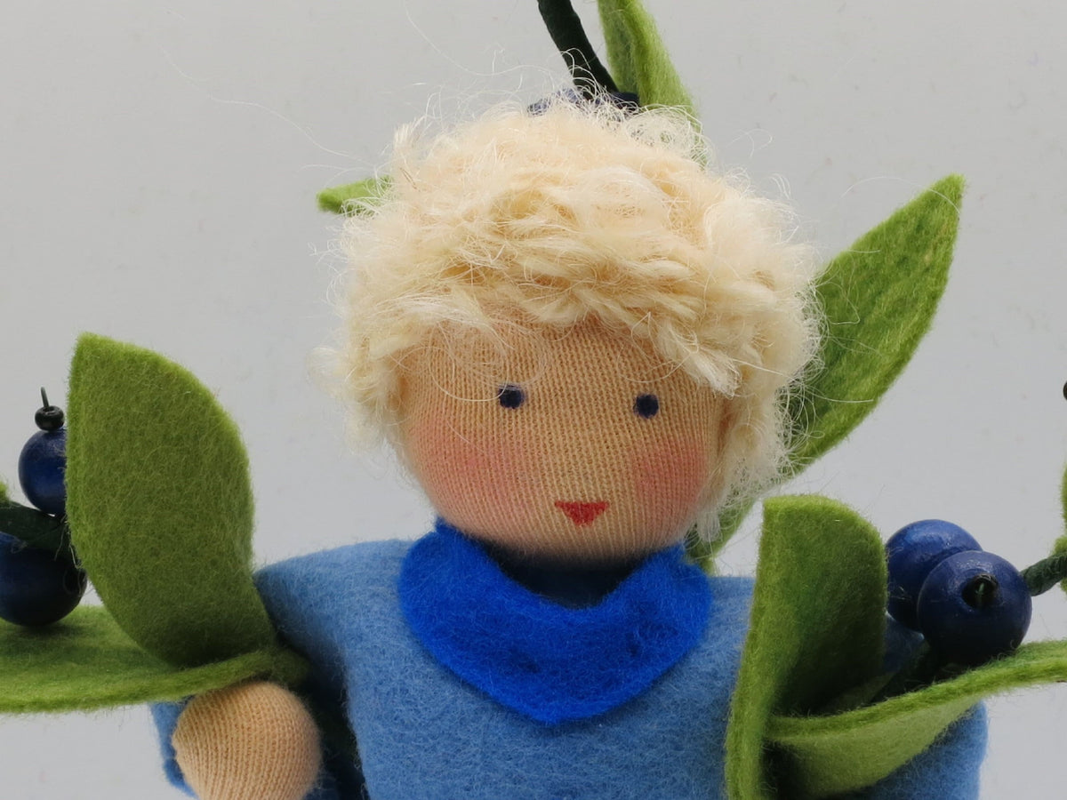 Nahaufnahme des Gesichts der Heidelbeere-Junge-Figur mit blauem Halstuch.