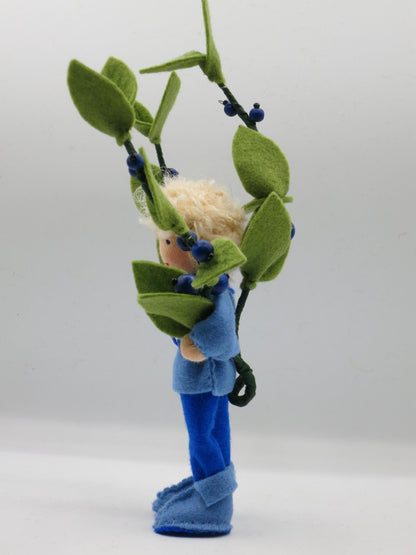 Seitenansicht des Heidelbeere-Jungen mit Beerenzweigen und blauen Filzstiefeln.