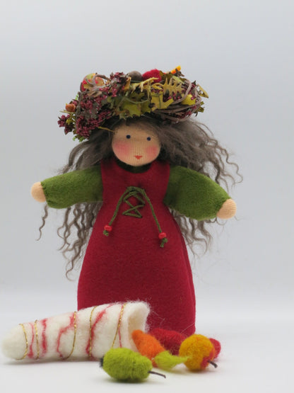 Herbst-Blumenkind mit rotem Filzkleid, Naturkranz und weißem Erntehorn mit bunten Filzfrüchten
