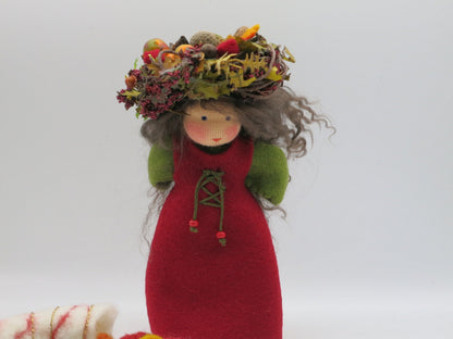 Handgefertigte Herbstfigur mit rotem Filzkleid, grünem Ärmeln und Naturkranz für den Waldorf-Jahreszeitentisch