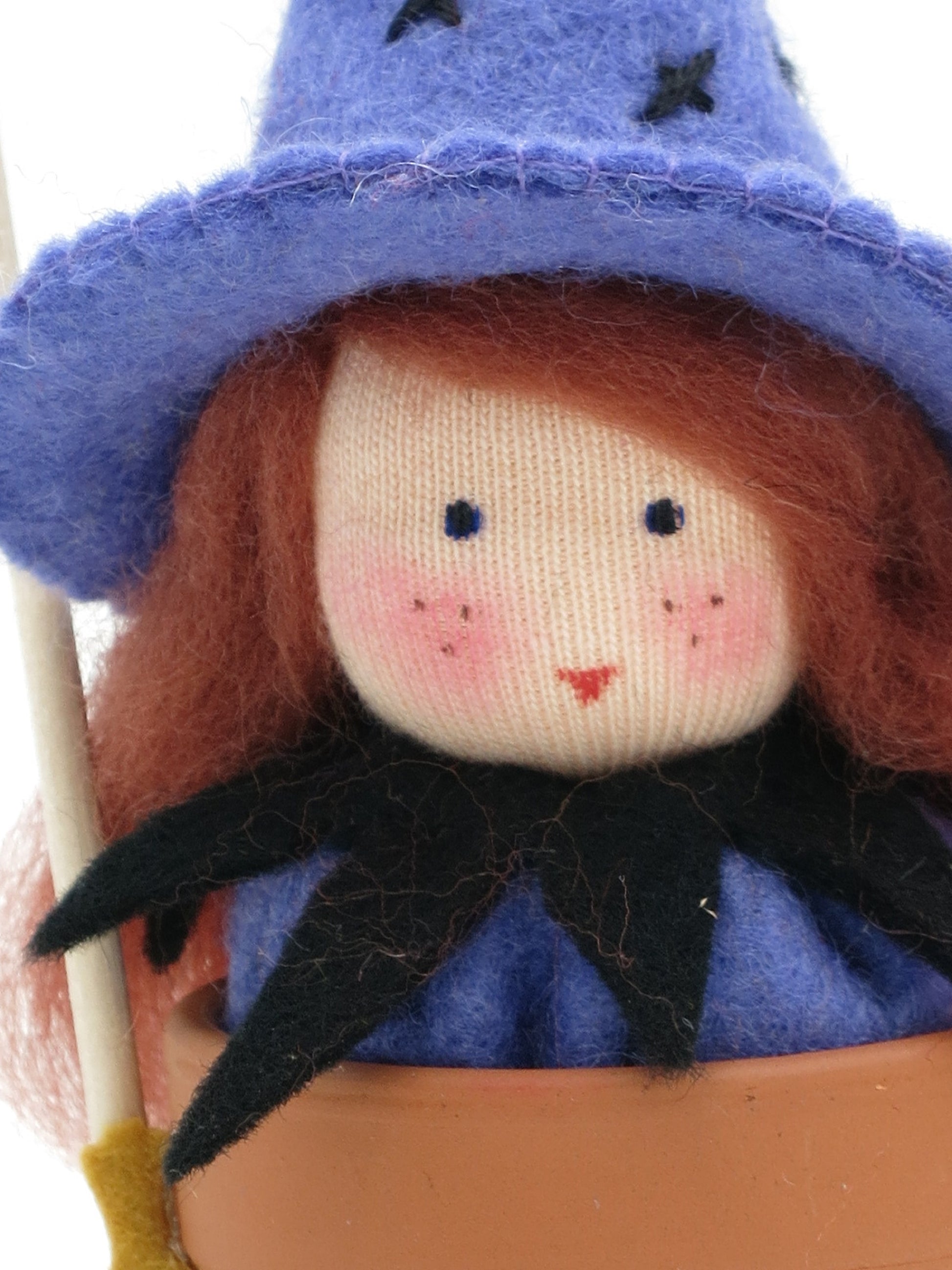 Nahaufnahme des Gesichts vom Hexentöpfchen Art. HE64 in Lila, Waldorf-Blumenkind für Halloween.