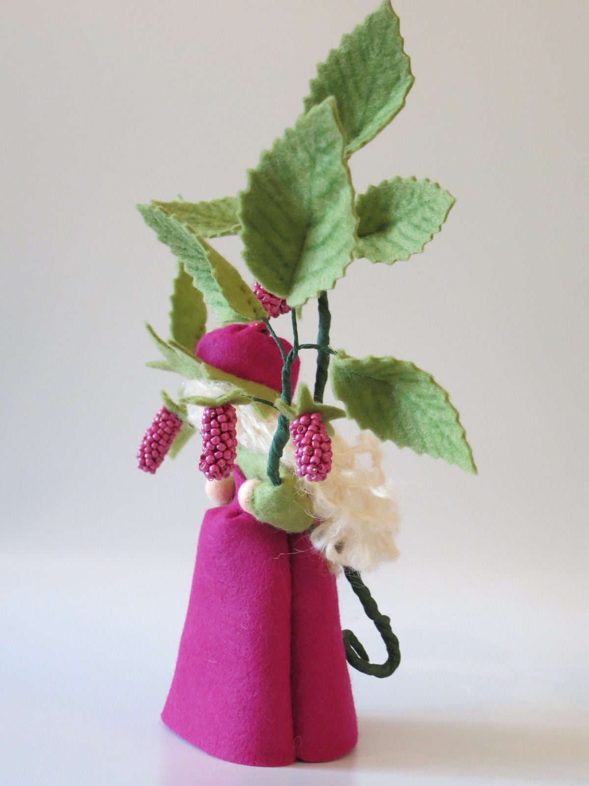 Rückansicht des Himbeere-Blumenkindes mit Perlen-Himbeeren am Zweig