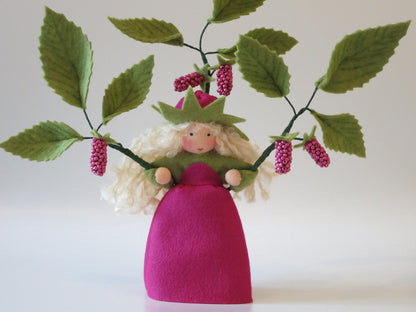 Detailansicht der vier pink-roten Perlen-Himbeeren am Zweig des Blumenkindes