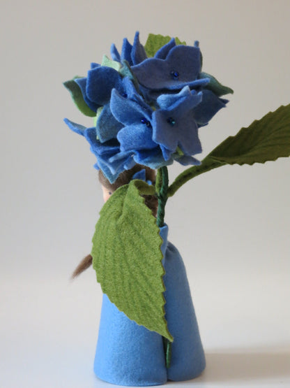 Rückansicht der blauen Hortensie mit geflochtenem Zopf und großem gezähntem Blatt.