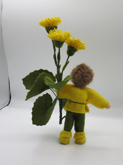 Rückansicht des Huflattich-Junge Waldorf Jahreszeitentisch Blumenkindes mit großen Filzblättern