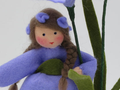 Gesamtansicht des Iris-Blumenkindes mit lila Kleid und zwei Blütenstielen