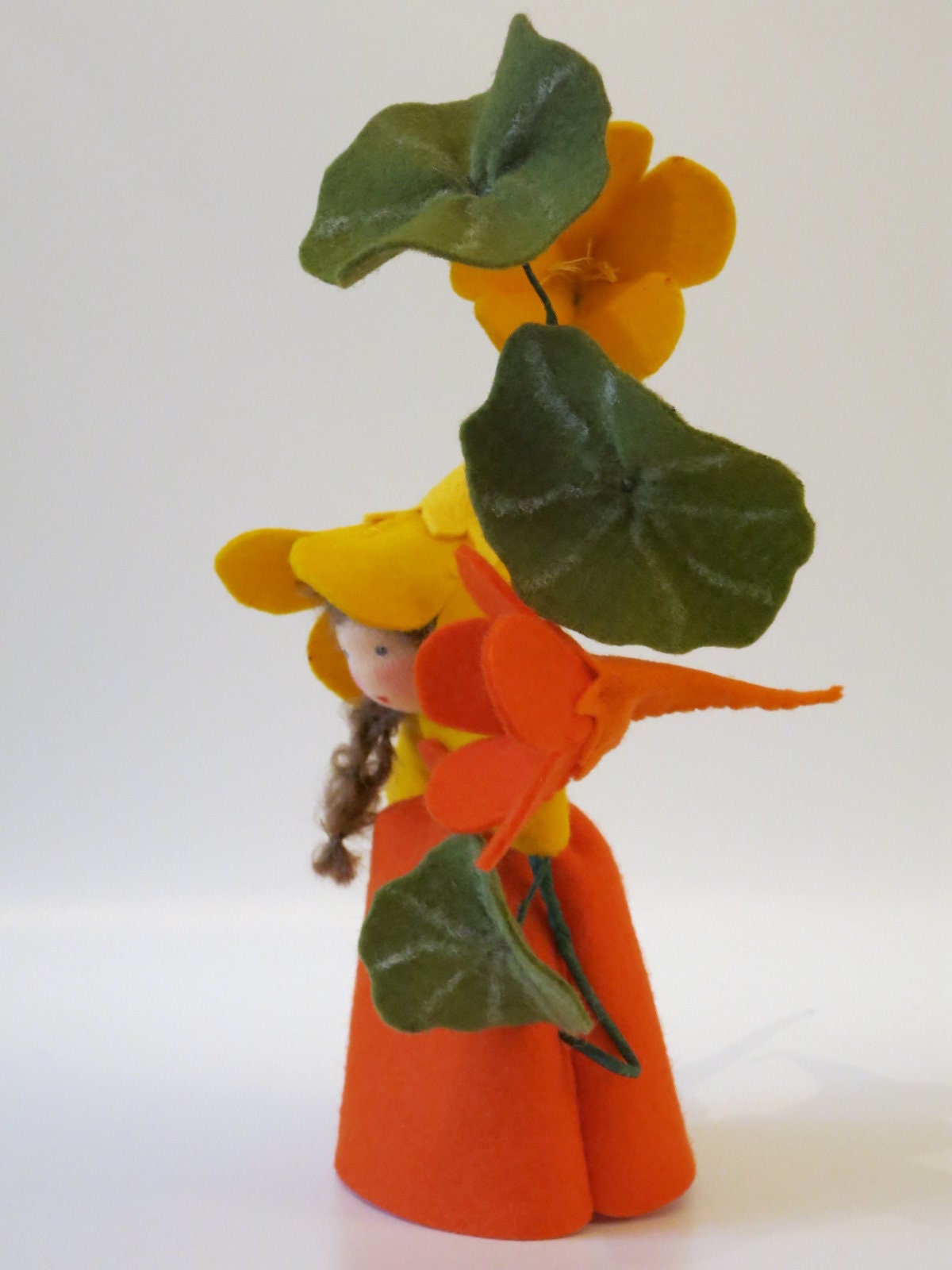 Rückansicht der Kapuzinerkresse-Figur mit gelber Trichterblüte und Schildblättern.