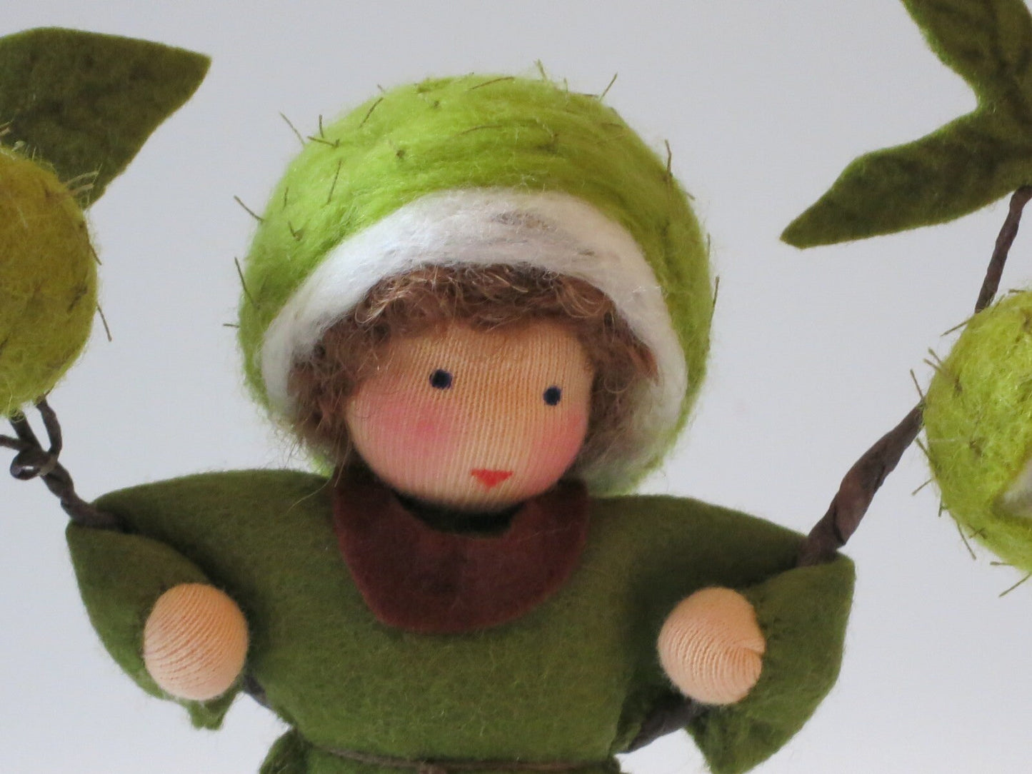 Kastanien-Junge Blumenkind aus Wollfilz, Nahaufnahme Gesicht mit stacheliger Kastanienhuelle, Waldorf-Jahreszeitentisch, Art. HE35