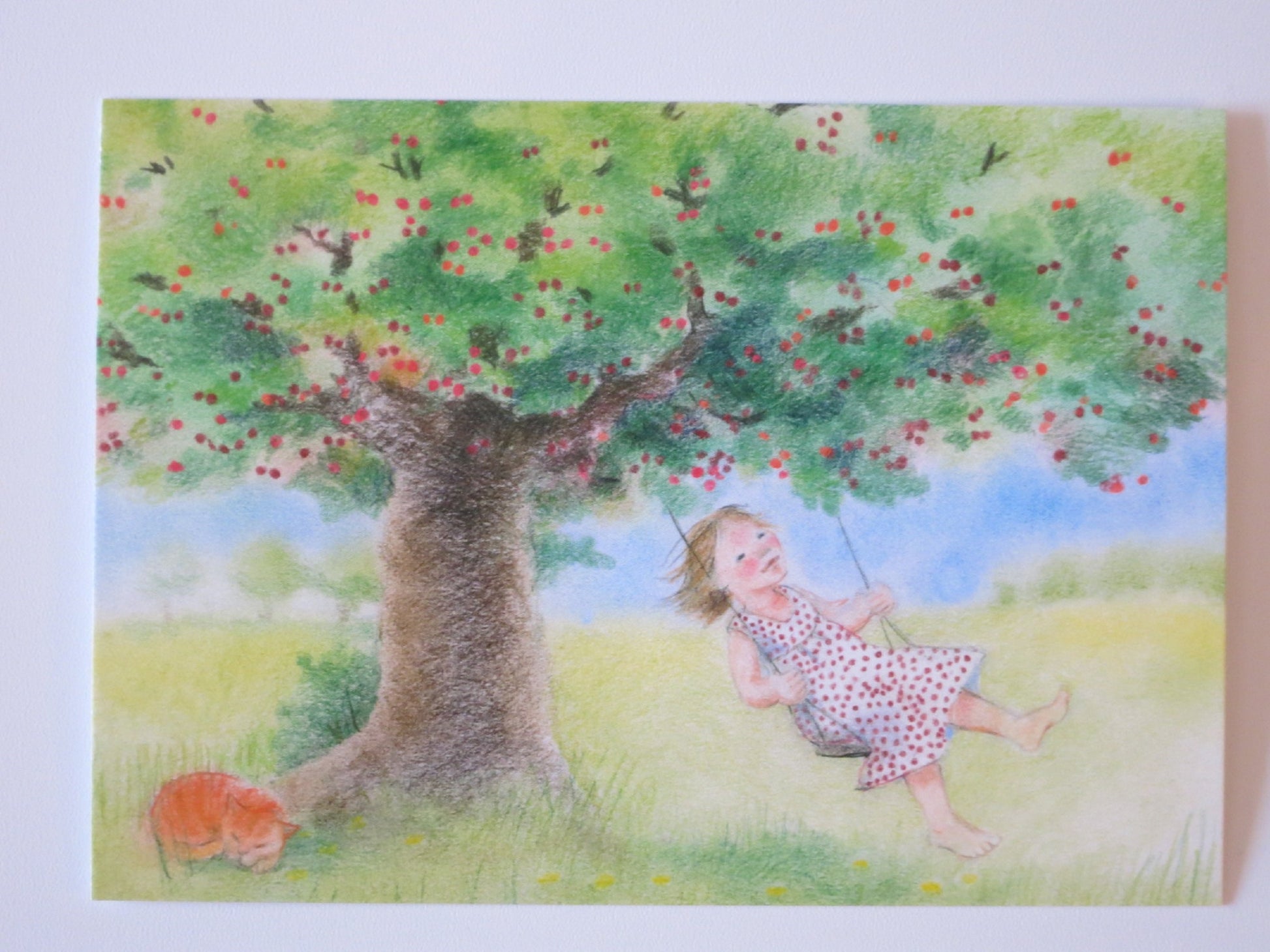 Waldorf Postkarte Kirschbaumschaukel von Sanne Dufft – Maedchen schaukelt unter Kirschbaum mit schlafender Katze