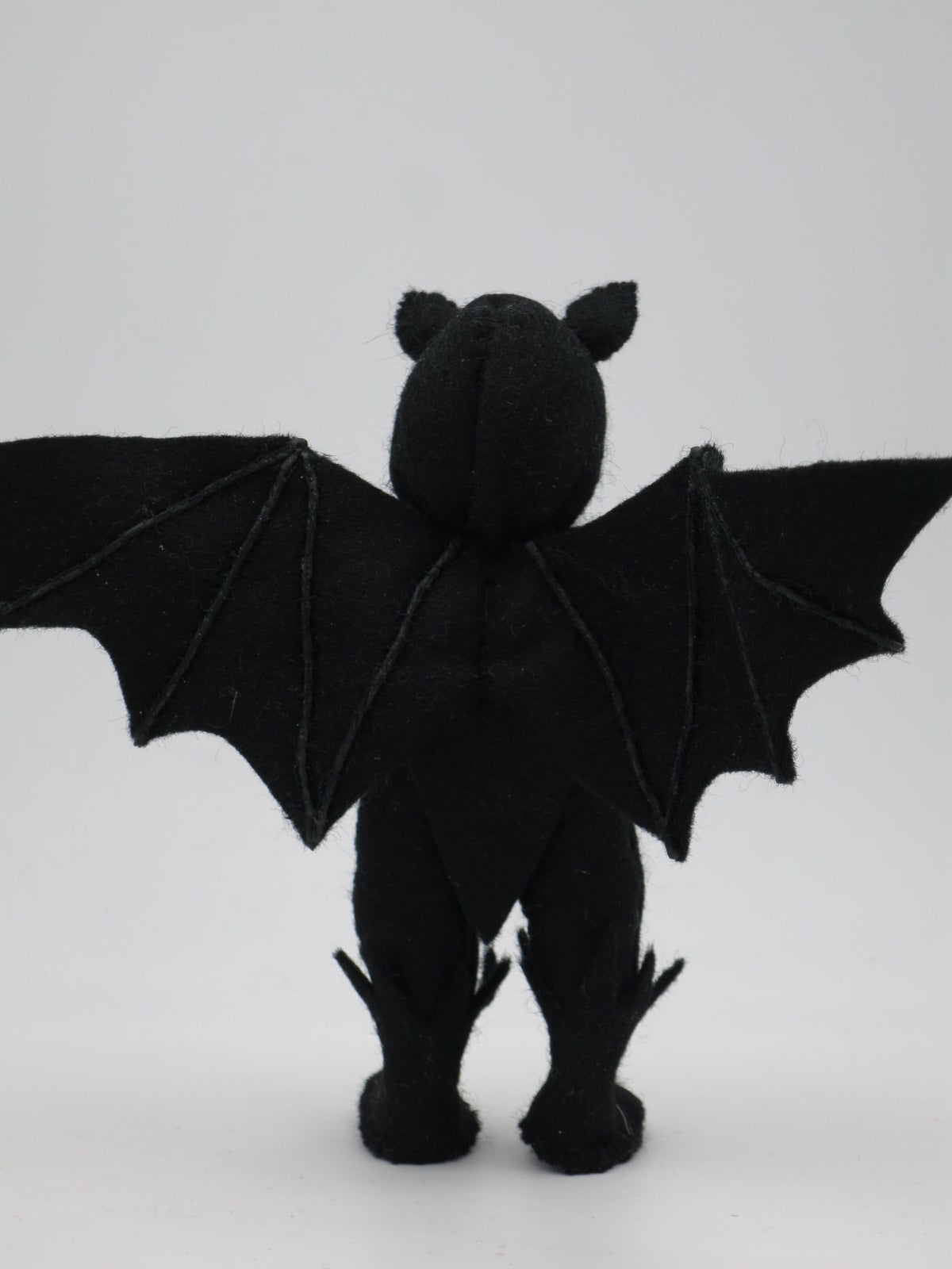 Rückansicht der Kleinen Fledermaus Art. HE67 mit beiden Flügeln, Waldorf-Blumenkind aus Wollfilz für den Jahreszeitentisch.