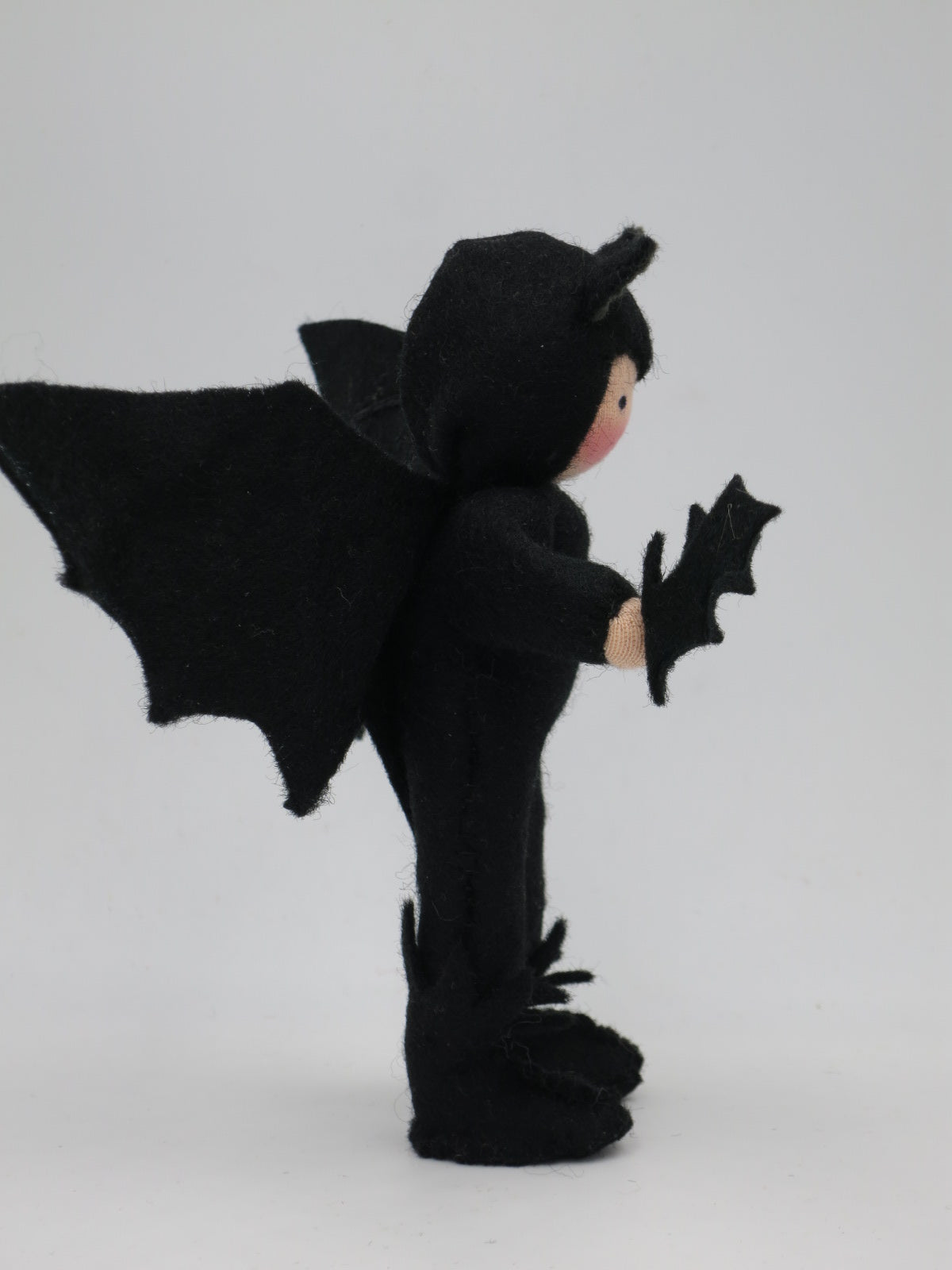 Profilansicht der Kleinen Fledermaus Art. HE67 mit Flügel und kleiner Filz-Fledermaus in der Hand, Waldorf-Jahreszeitentisch.