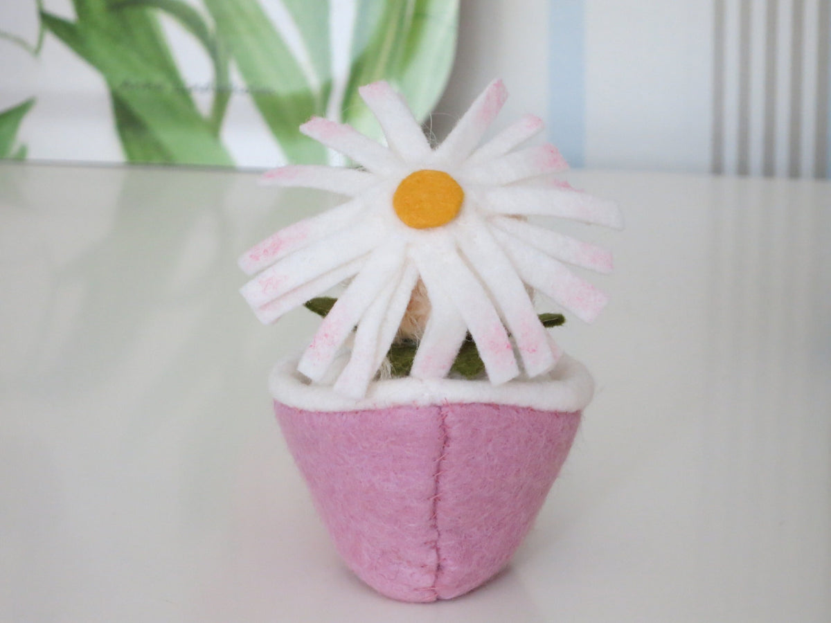 Kleine Margerite mit gelb-weißer Filzblüte um die Puppenfigur geschlossen, Waldorf-Wollfilzfigur