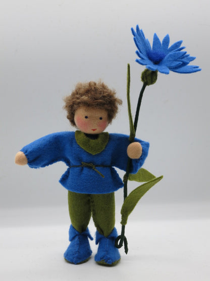 Kornblume-Blumenkind aus Wollfilz in blau-grüner Kleidung mit blauer Sternblüte, zweite Ansicht.