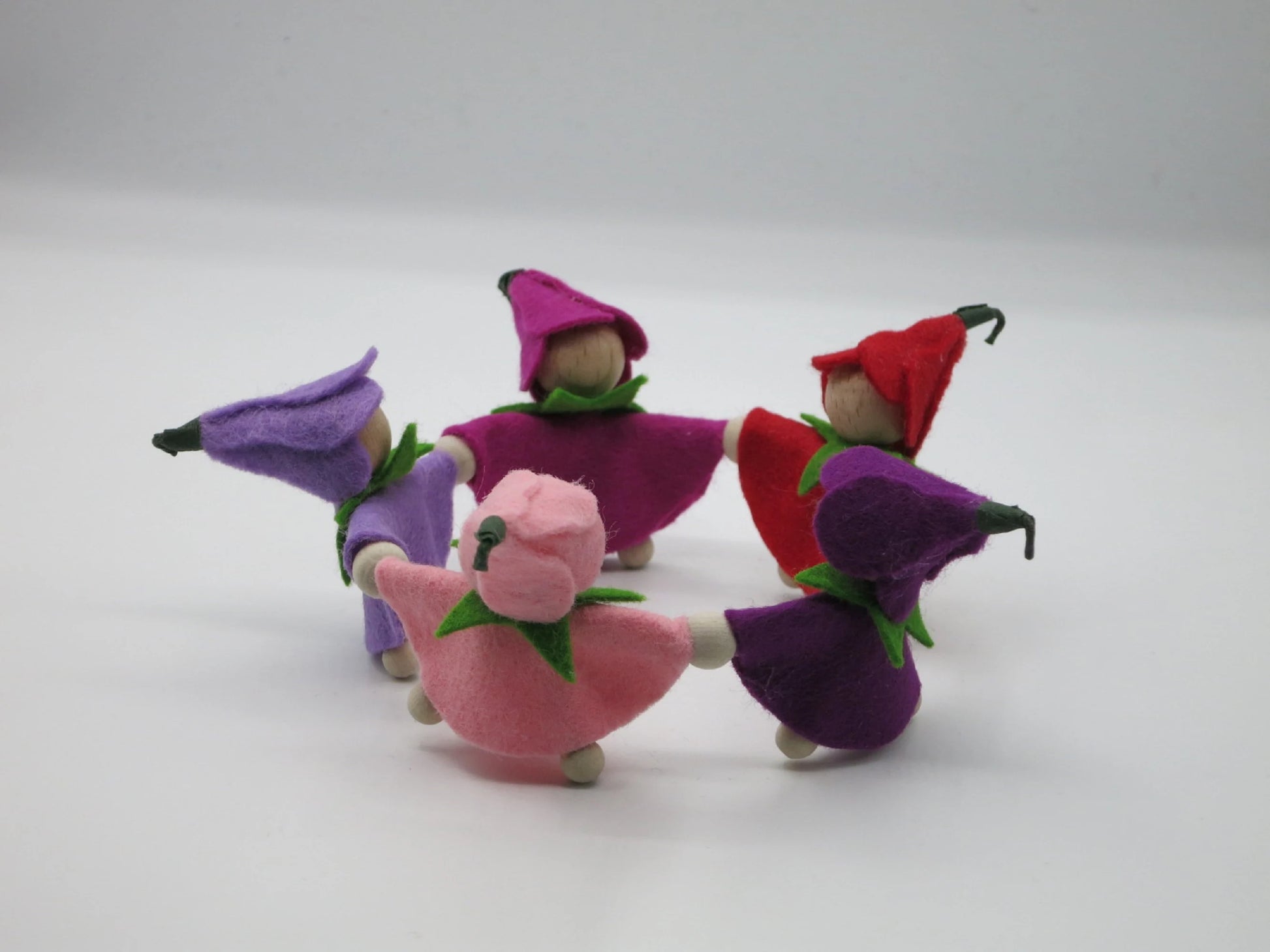 Seitenansicht des Krokus-Kränzchens mit violetten, rosafarbenen und roten Filz-Blumenkindern auf hellem Hintergrund.