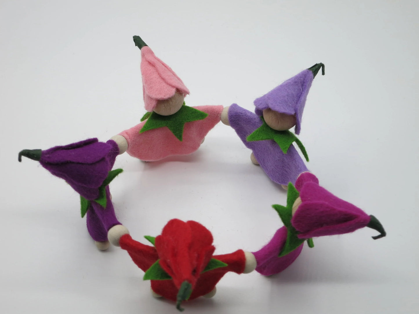 Draufsicht auf den geschlossenen Kreis aus fünf handgefertigten Krokus-Blumenkindern mit spitzen Filzblütenhüten.