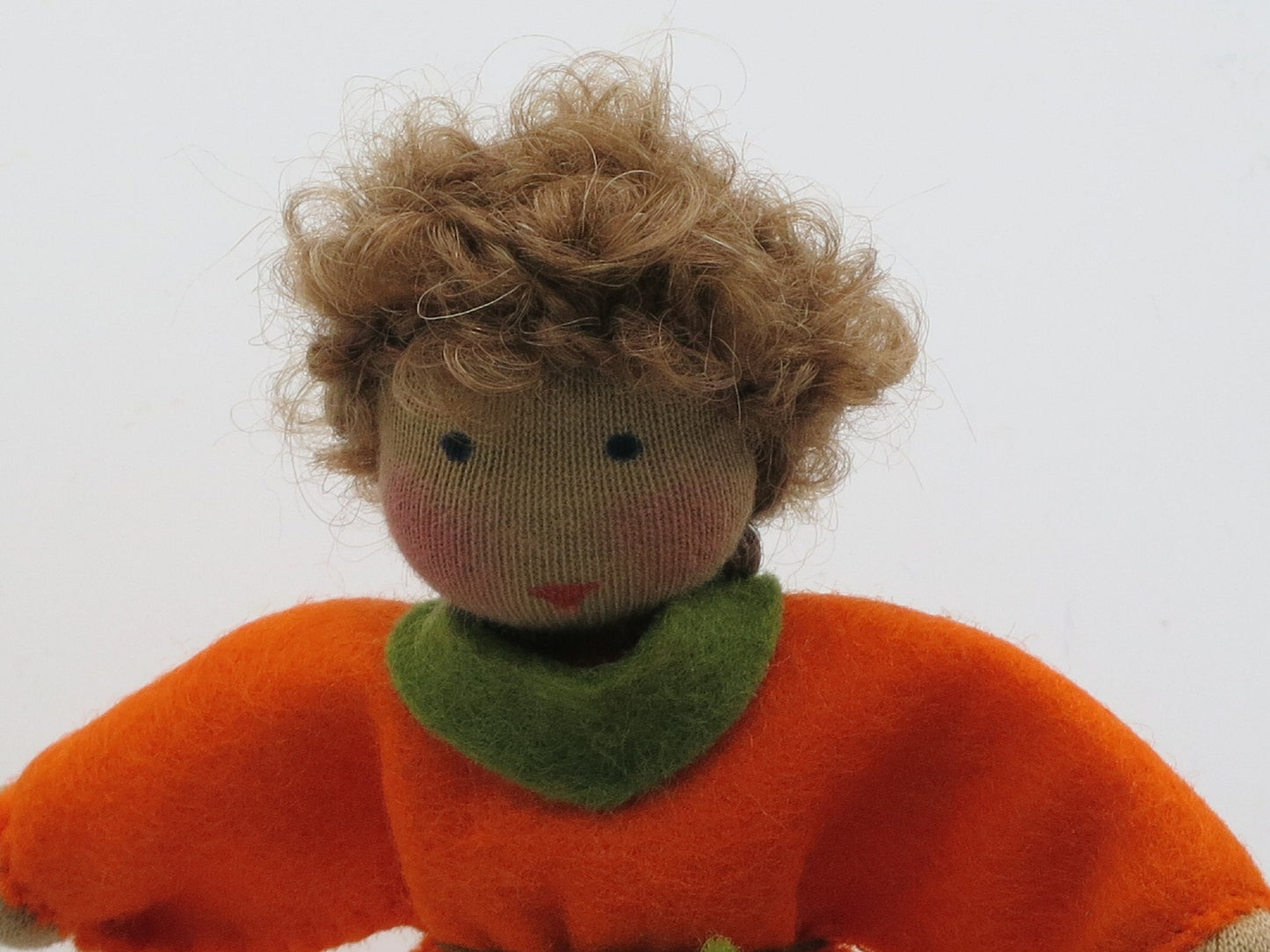 Nahaufnahme des Gesichts vom Kürbis-Jungen Art. HE51 mit lockigem Haar, Waldorf-Jahreszeitentisch Herbst.