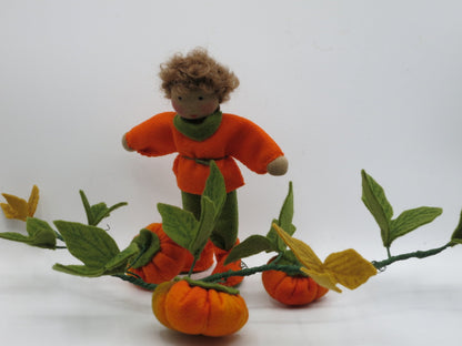 Kürbis-Junge Art. HE51 in oranger Tunika neben der Kürbisranke mit Filzkürbissen, Waldorf-Blumenkind.