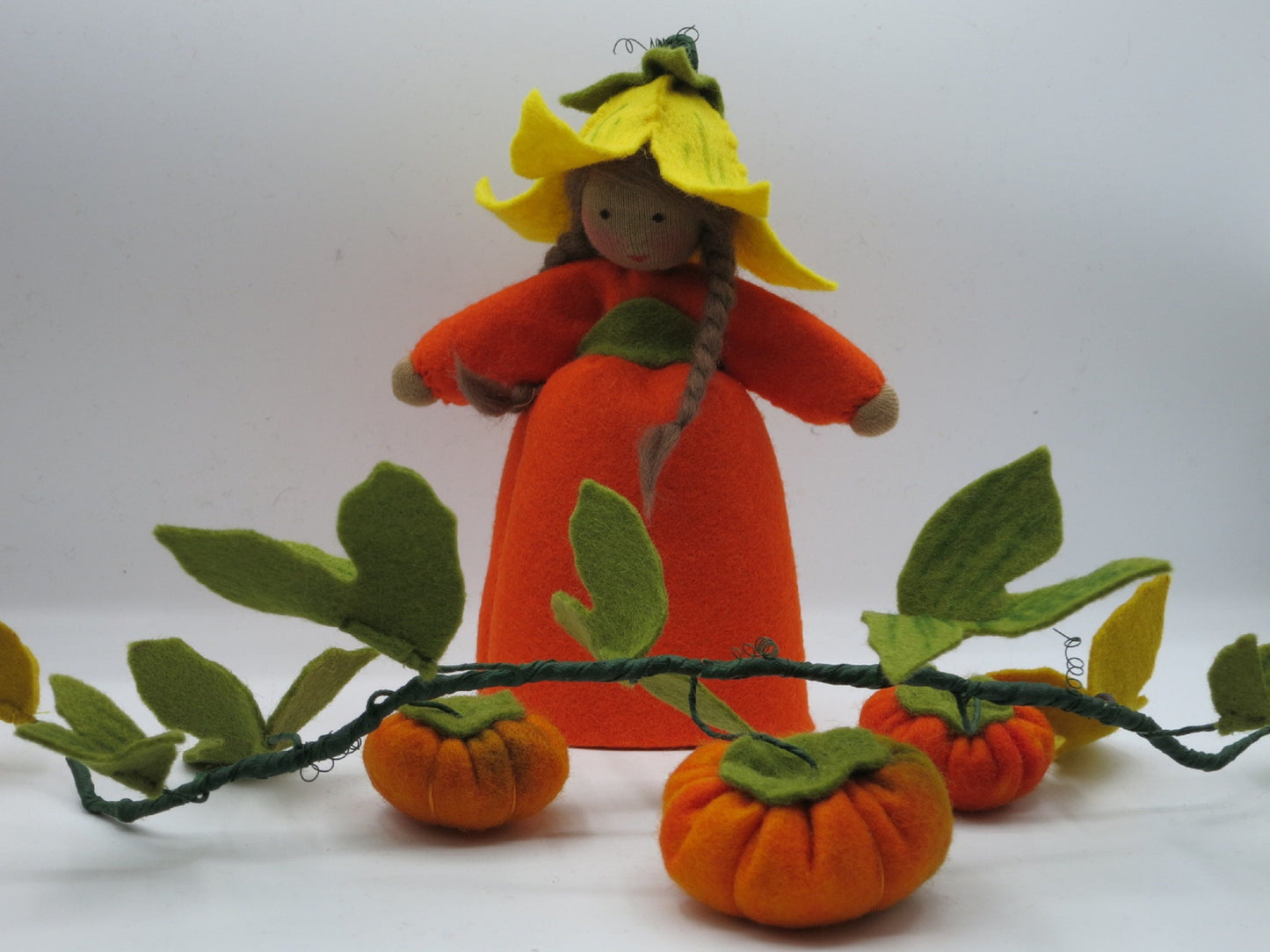 Kürbis-Mädchen Art. HE51 mit braunem Zopf, orangem Kürbiskleid und Kürbisranke, Waldorf-Jahreszeitentisch.