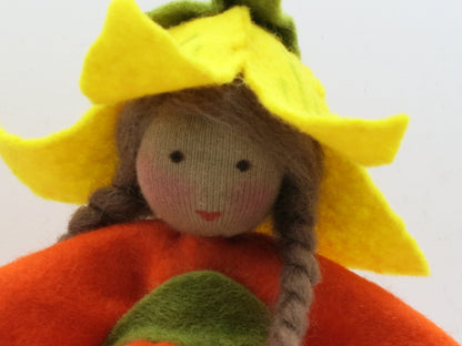 Detailaufnahme des Gesichts unter der gelben Blütenhaube am Kürbis-Mädchen Art. HE51, Waldorf-Blumenkind Herbst.