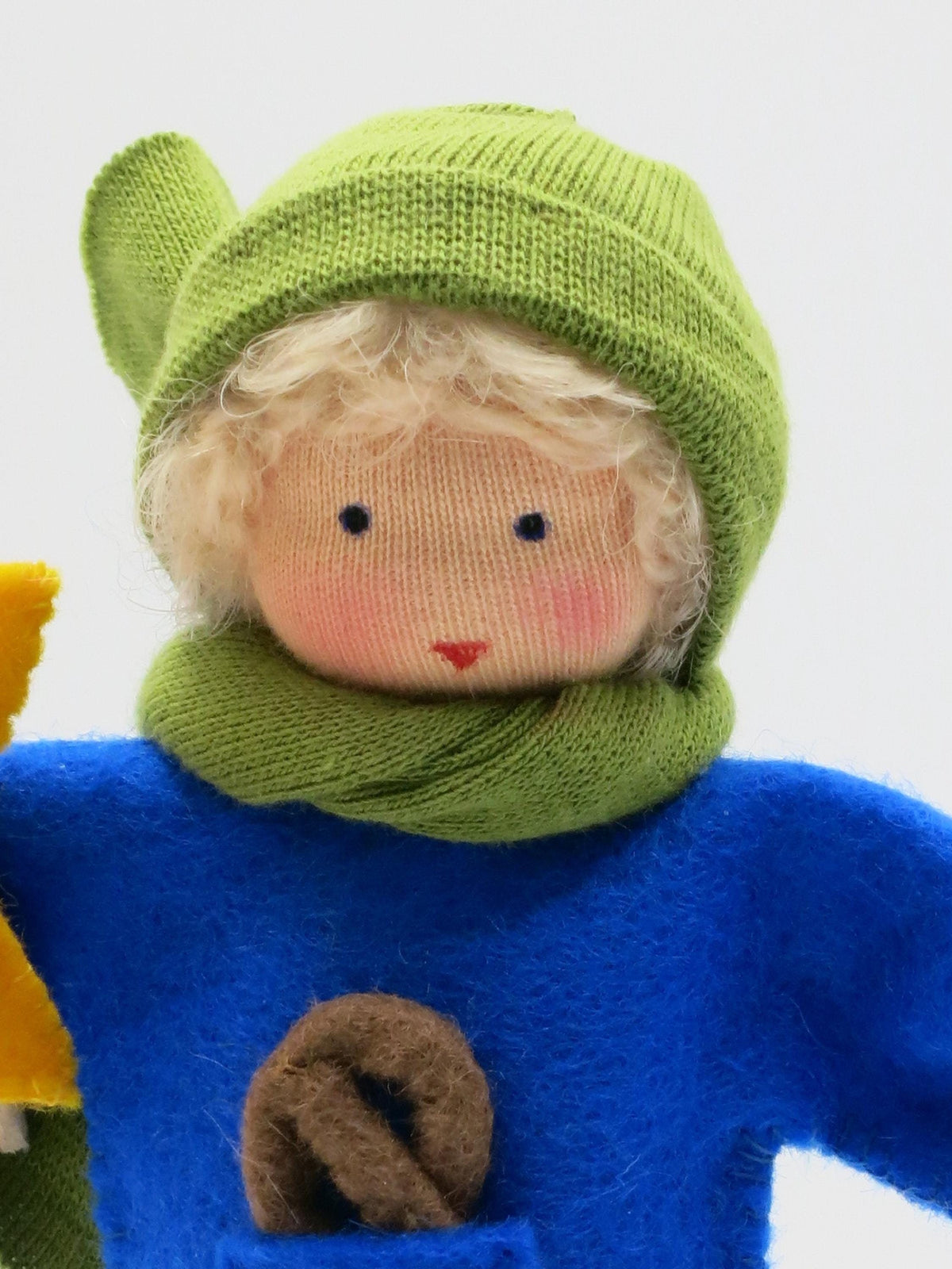Gesichtsdetail des Laternenkinds in Blau mit grüner Strickmütze, grünem Schal und blauem Wollfilzpullover.