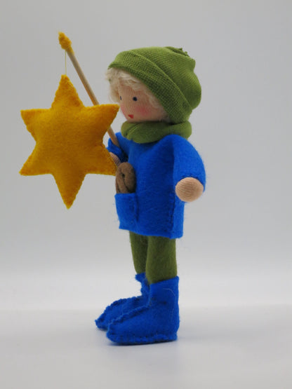 Seitenansicht des Laternenkinds in Blau mit gelber Sternlaterne und grüner Strickmütze.