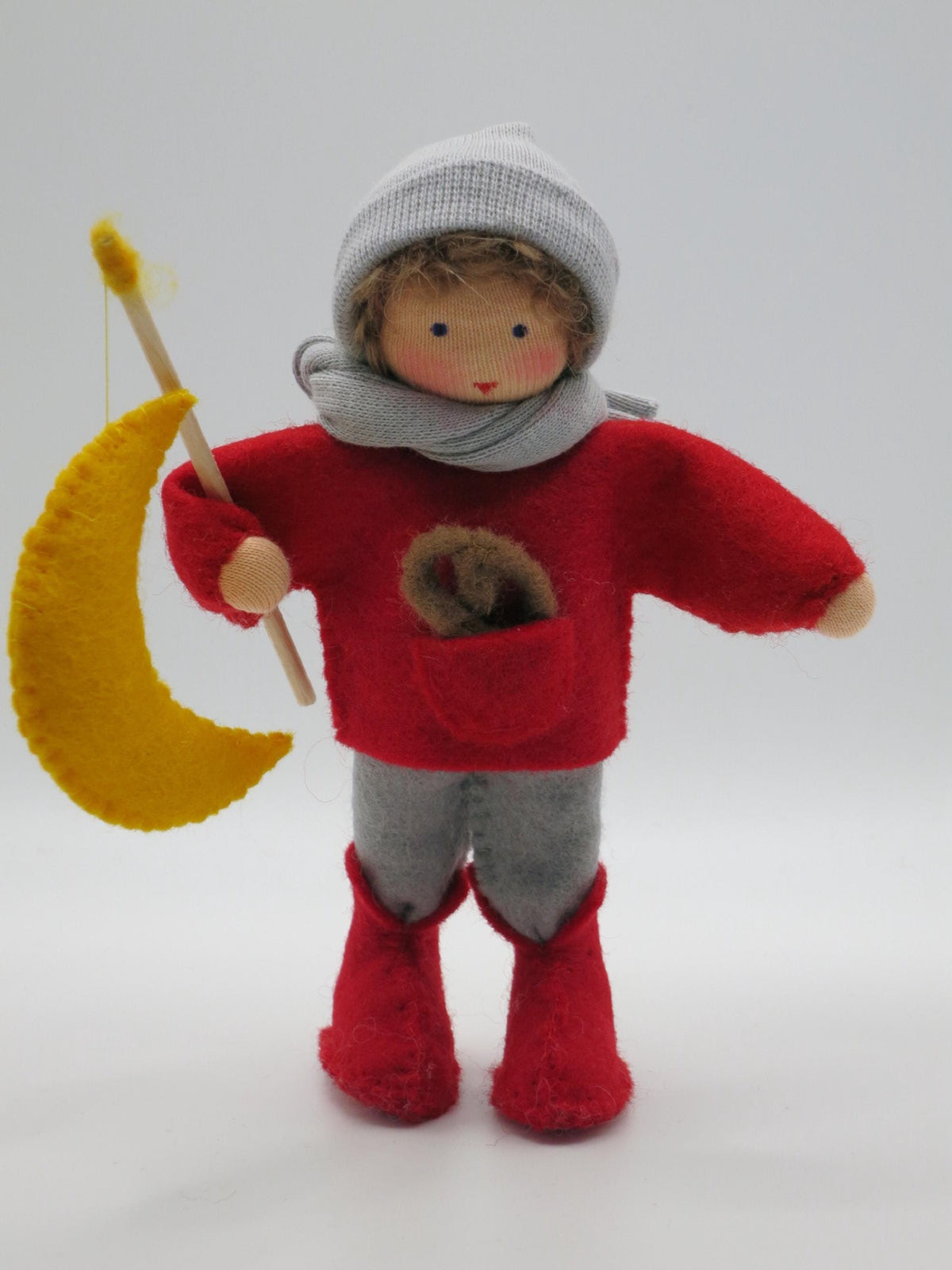 Laternenkind aus Wollfilz mit gelber Mondlaterne am Holzstab, rotem Pullover und grauer Mütze, Figur für Sankt Martin und den Waldorf Jahreszeitentisch.