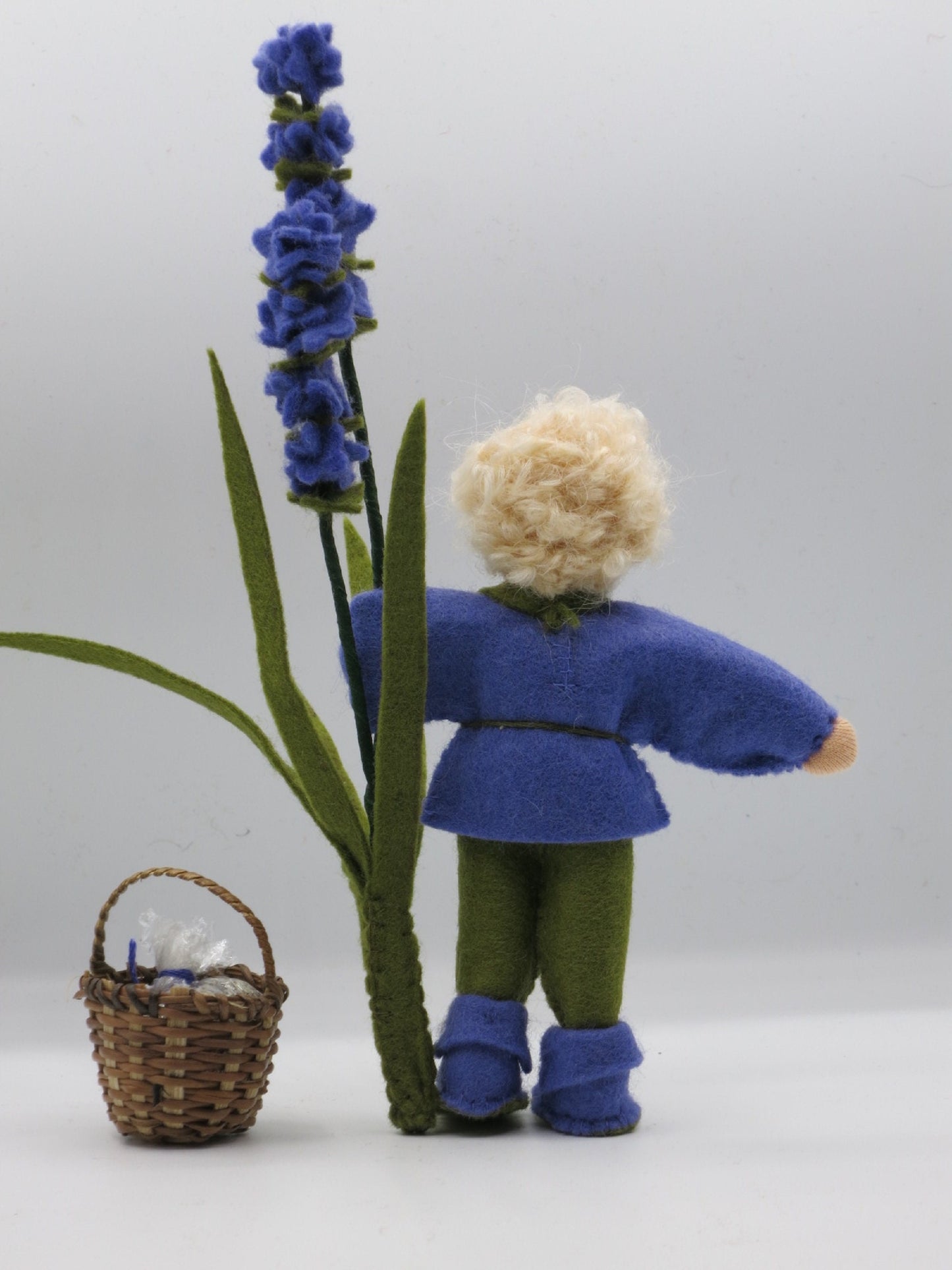 Rückansicht des Lavendel-Jungen aus Wollfilz mit grüner Hose, Waldorf-Jahreszeitentisch