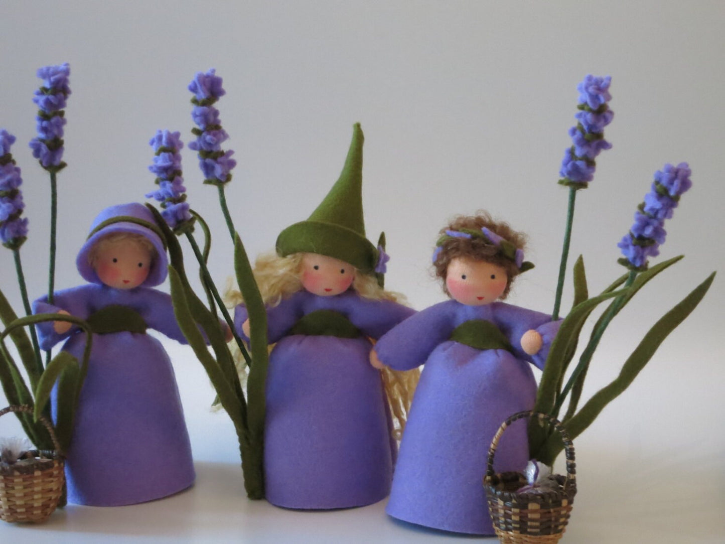 Drei Lavendel-Figuren im Vergleich: Rundhut- und Spitzhut-Variante des Lavendel-Mädchens sowie eine zusätzliche Blütenkranz-Figur als Deko.