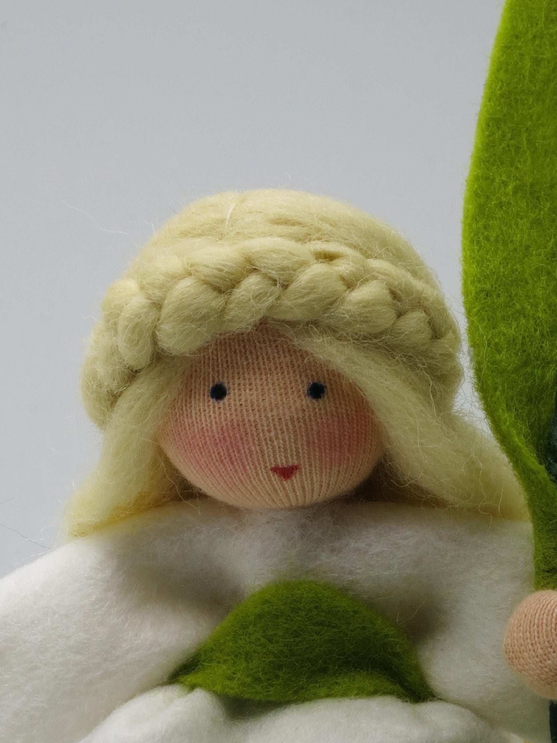 Nahaufnahme Gesicht Lilie-Blumenkind mit Zopfkranz aus Wollfilz, Waldorf-Jahreszeitentisch