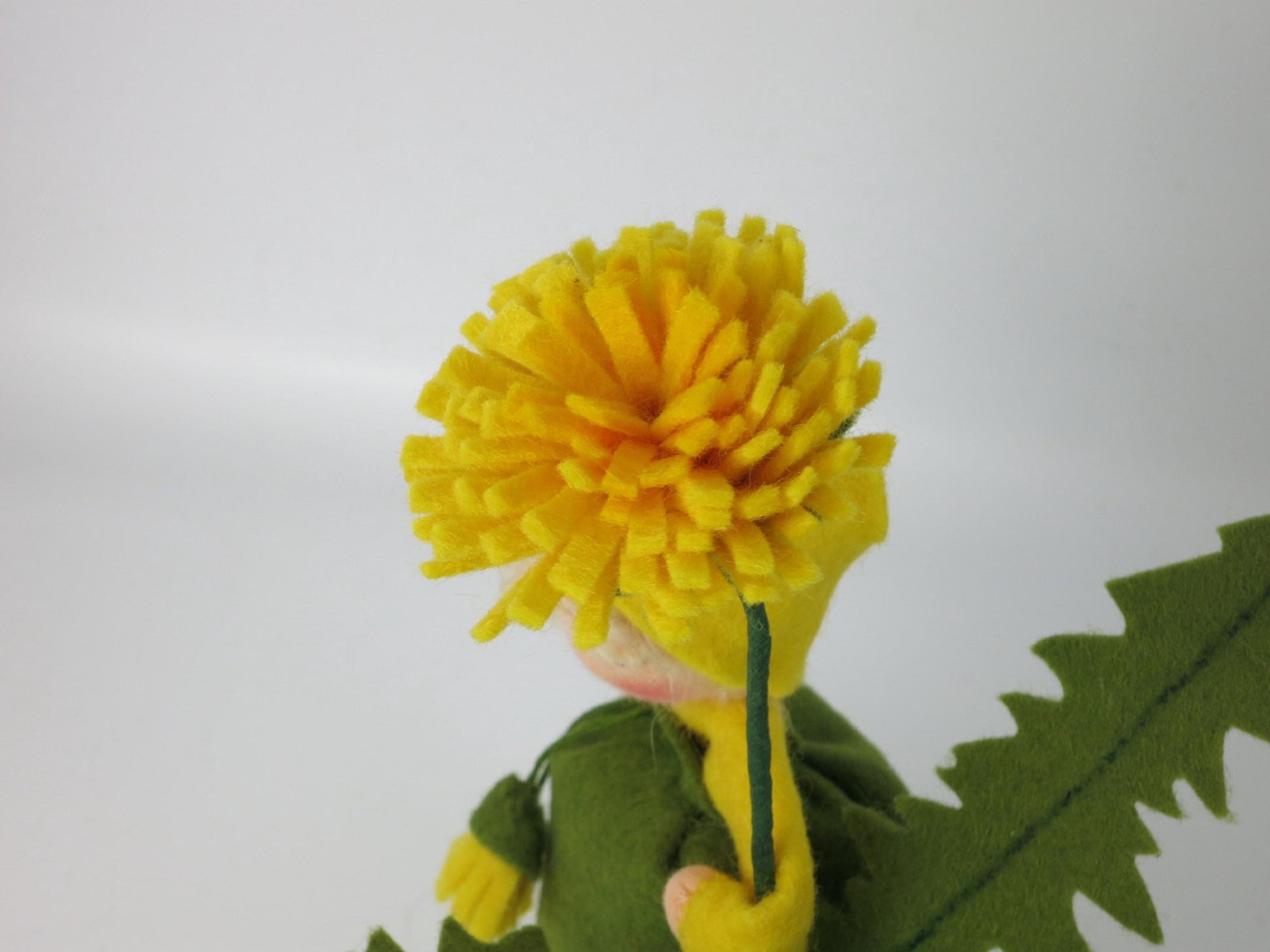 Seitenansicht Löwenzahn-Blumenkind mit grünem Filzkleid und gelber Blüte, Waldorf-Jahreszeitentisch Sommer