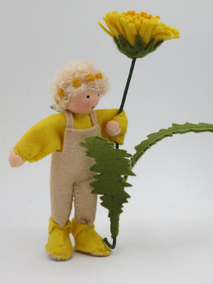 Löwenzahn-Junge Blumenkind hält das gezähnte Löwenzahnblatt in der Hand, Waldorf Jahreszeitentisch